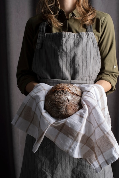 Close up baker holding bread