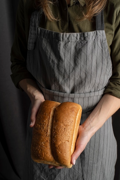 Close up baker holding bread