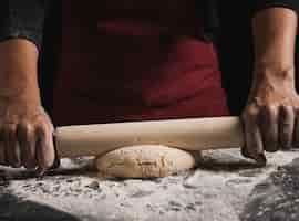 Free photo close-up baker rolling dough composition