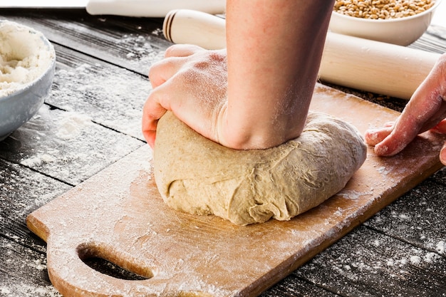 Close-up of baker's hand kneading dough for bread