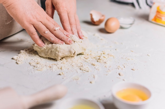 Close-up of a baker's hand kneading dough