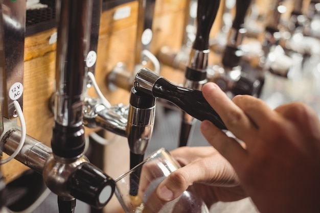 Close-up of bar tender filling beer from bar pump