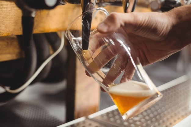 Close-up of bar tender filling beer from bar pump