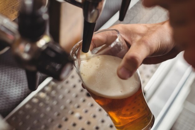 Крупный план барного тендера, разливающего пиво из барного насоса