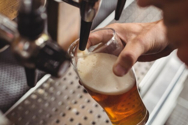 Close-up of bar tender filling beer from bar pump