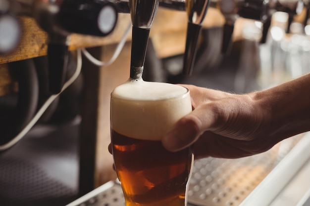 Close-up of bar tender filling beer from bar pump