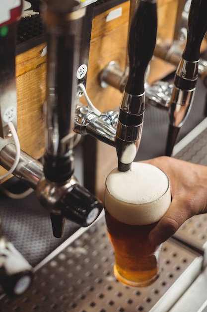 Close-up of bar tender filling beer from bar pump