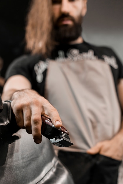 Close-up of a barber's hand with electric trimmer