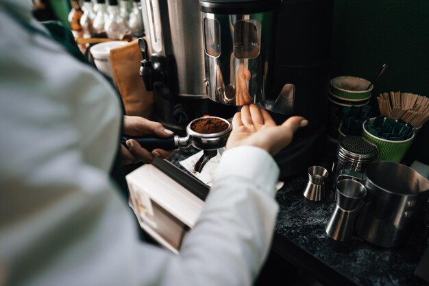 コーヒーショップで顧客のためにコーヒーを準備するバリスタの手のクローズアップ