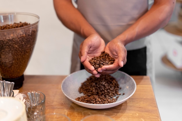 Foto gratuita primo piano barista che tiene i chicchi di caffè coffee