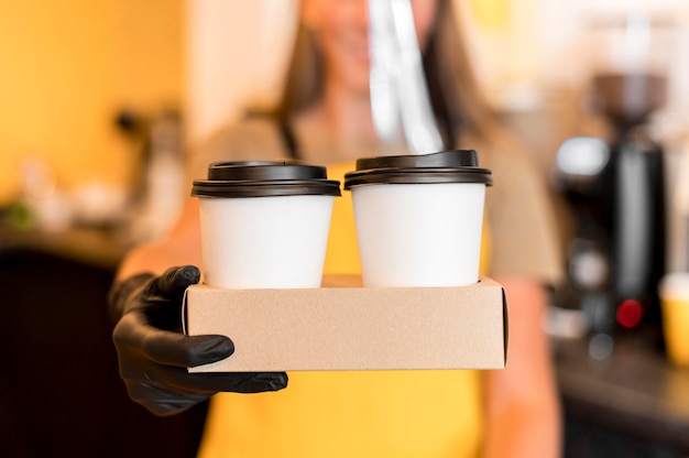 Close-up barista with gloves serving coffee