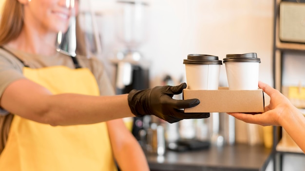 Barista di close-up con guanti di lavoro