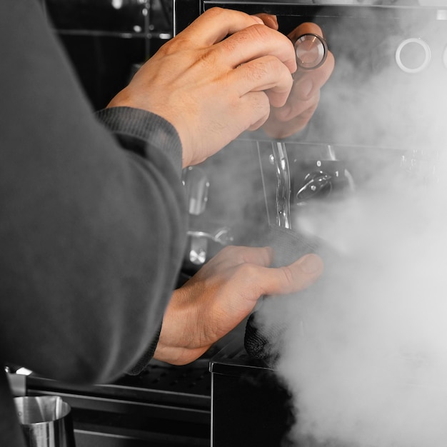 Foto gratuita barista di primo piano che lavora con il vapore