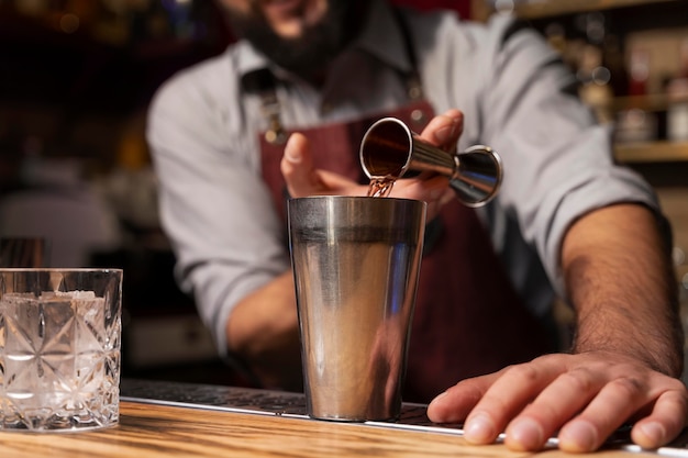 Close up on bartender and cocktail shaker