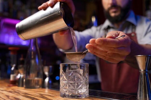 Close up on bartender and cocktail shaker