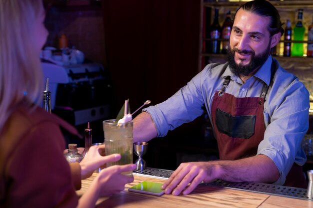 Close up on bartender and cocktail shaker