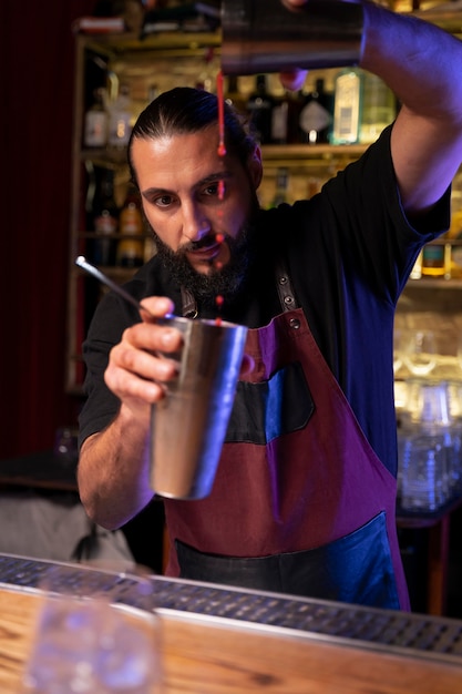 Close up on bartender and cocktail shaker