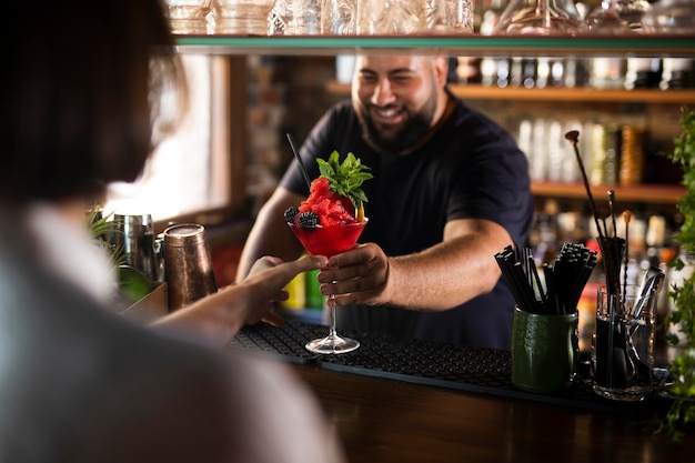 Foto gratuita primo piano sul barista che crea un drink delizioso?