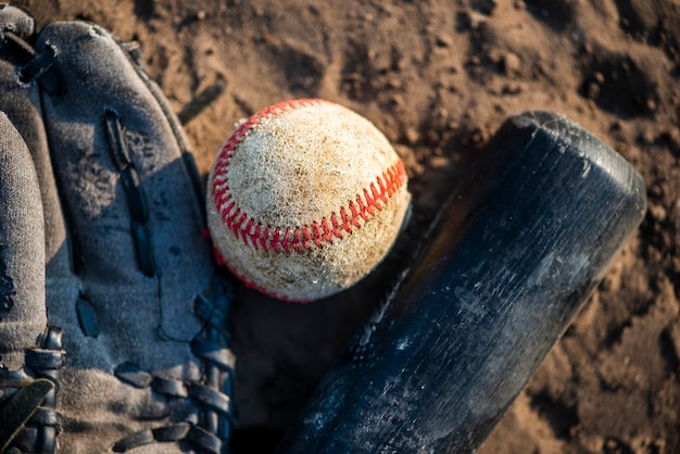 Close-up of baseball and bat in dirt