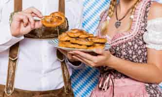 Free photo close-up bavarian couple holding pretzels