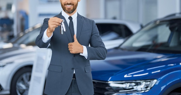 Free photo close up of bearded man in suit showing keys from new car