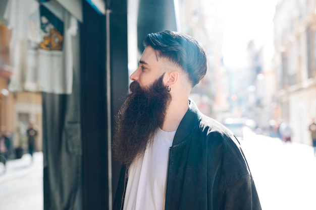Close-up of a bearded young man doing window shopping