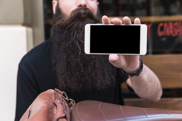 휴대 전화 화면을 보여주는 수염 된 젊은 남자의 클로즈업