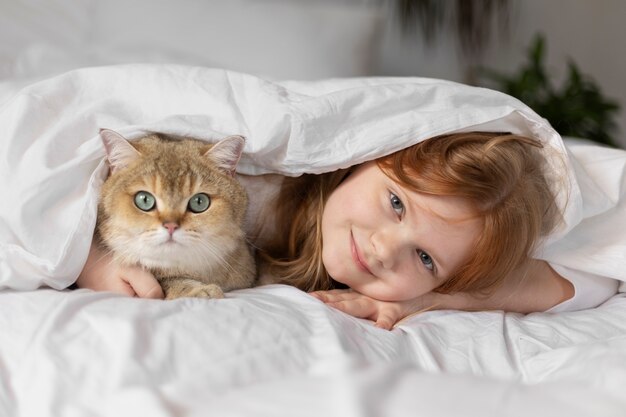 小さな女の子と美しい猫のクローズアップ