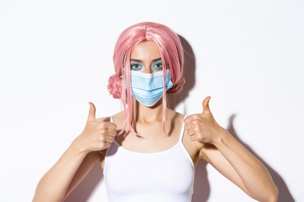 Close-up of beautiful confident girl with pink hair and medical mask