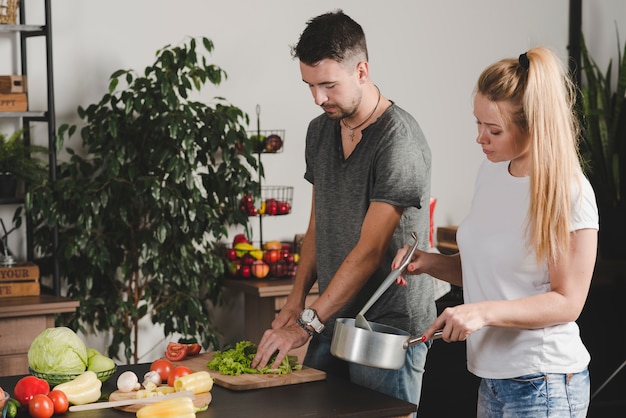 Close-up of beautiful couple preparing food in the kitchen