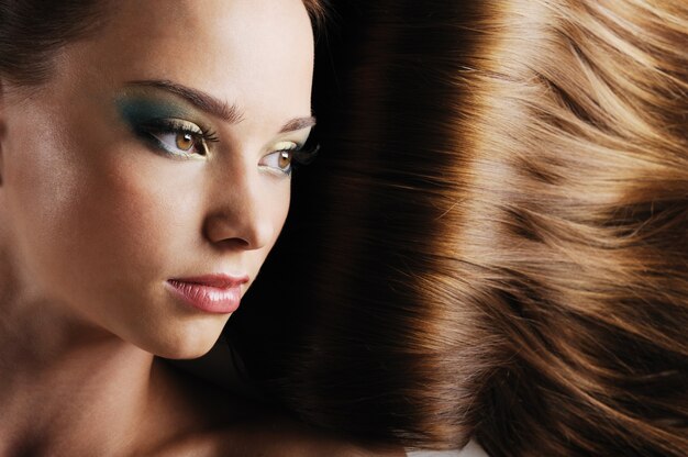 Close-up beautiful female face with luxuriant long hair as a space