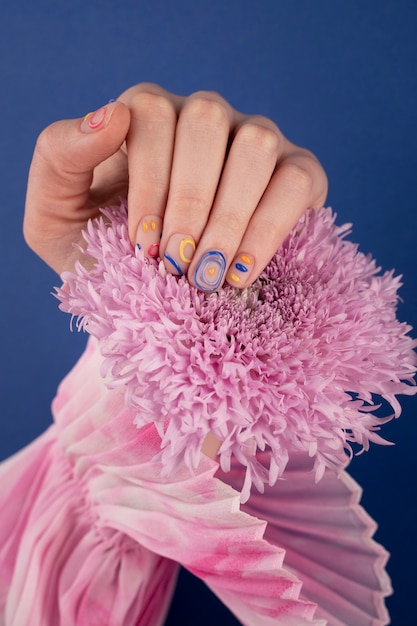 Close up beautiful manicure holding purple flower