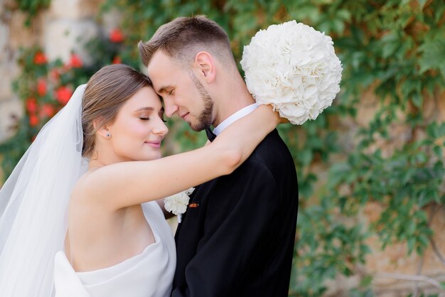 Close up of beautiful newlyweds hugging on the street