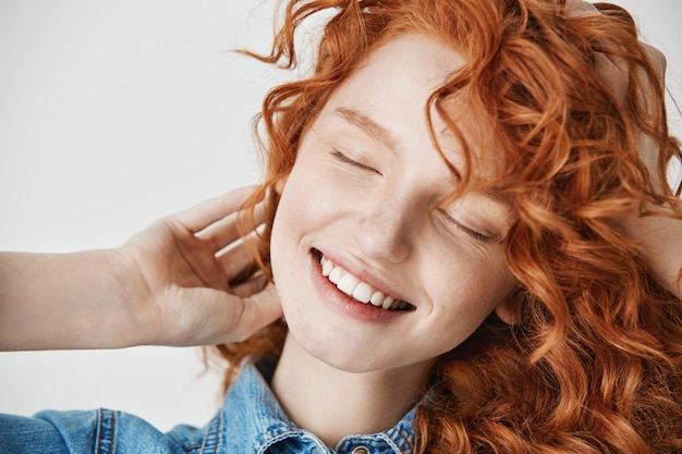 Chiuda in su di bella ragazza di redhead che sorride con gli occhi chiusi