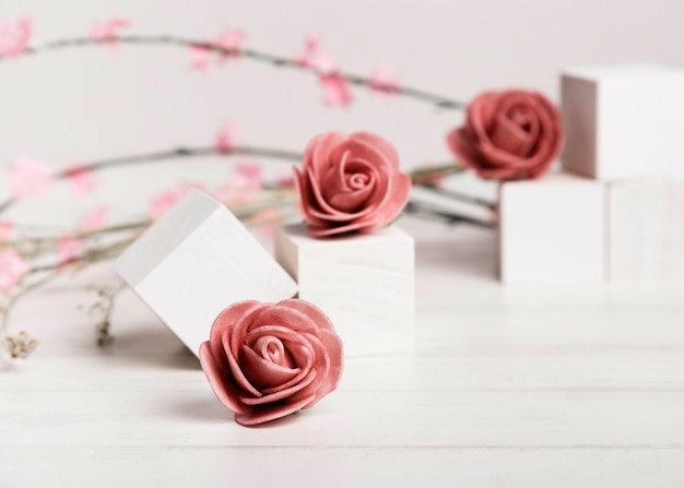 Foto gratuita belle rose del primo piano con i cubi bianchi