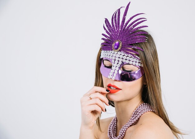 Крупный план красивой женщины, носящей карнавальную маску и бусы, ожерелье