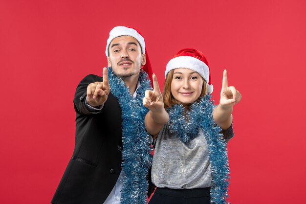 Close up on beautiful young couple wearing Santa hats isolated