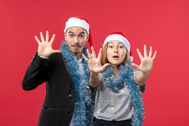 Close up on beautiful young couple wearing Santa hats isolated