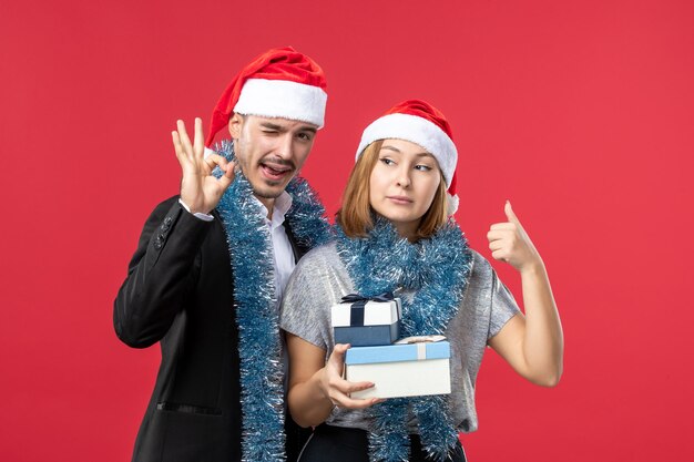 Close up on beautiful young couple wearing Santa hats isolated