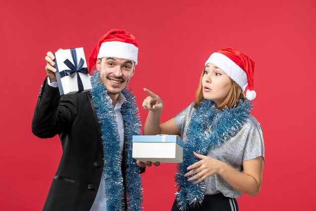 Close up on beautiful young couple wearing Santa hats isolated