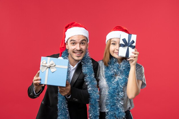 Free photo close up on beautiful young couple wearing santa hats isolated