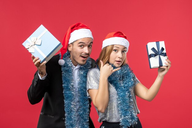 Close up on beautiful young couple wearing Santa hats isolated