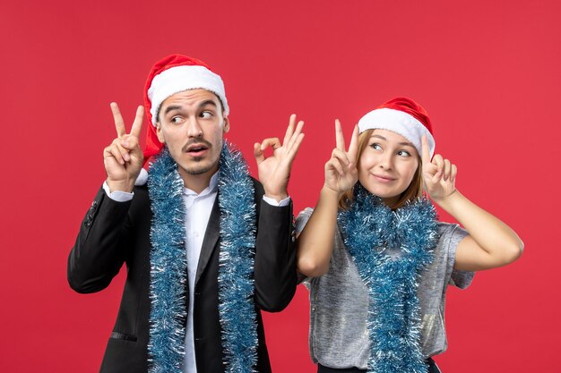 Close up on beautiful young couple wearing Santa hats isolated