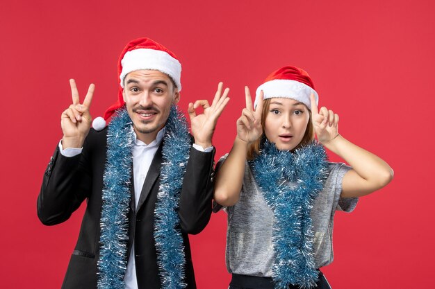 Close up on beautiful young couple wearing Santa hats isolated