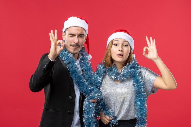 Close up on beautiful young couple wearing Santa hats isolated