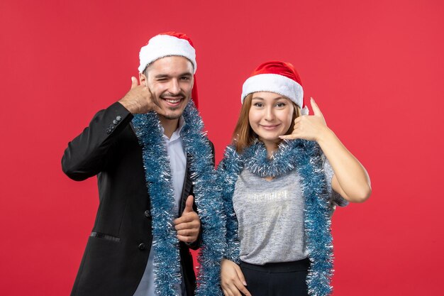 Close up on beautiful young couple wearing Santa hats isolated