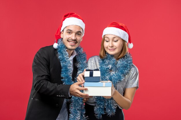 Close up on beautiful young couple wearing Santa hats isolated