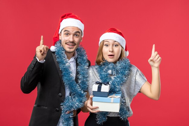 Close up on beautiful young couple wearing Santa hats isolated