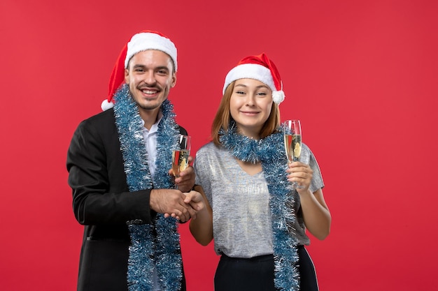 Free photo close up on beautiful young couple wearing santa hats isolated