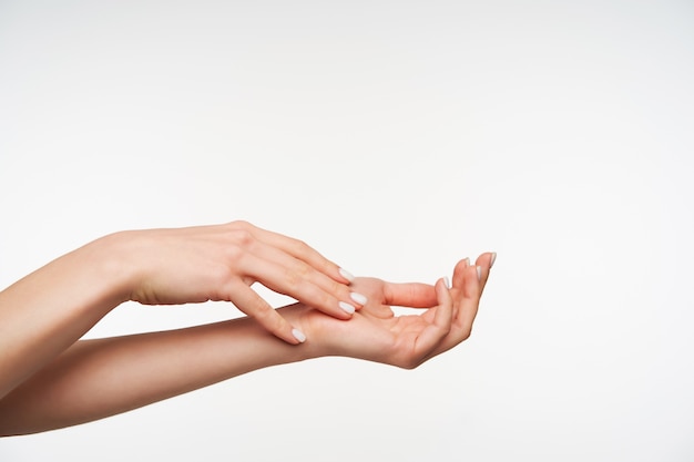 Free photo close up on beautiful young raised woman's hand with white manicure